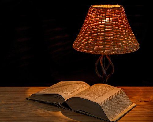 A warmly lit reading corner with an armchair and floor lamp