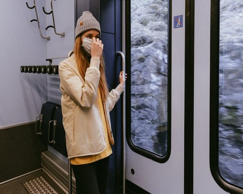 Person holding smartphone during evening commute on a train